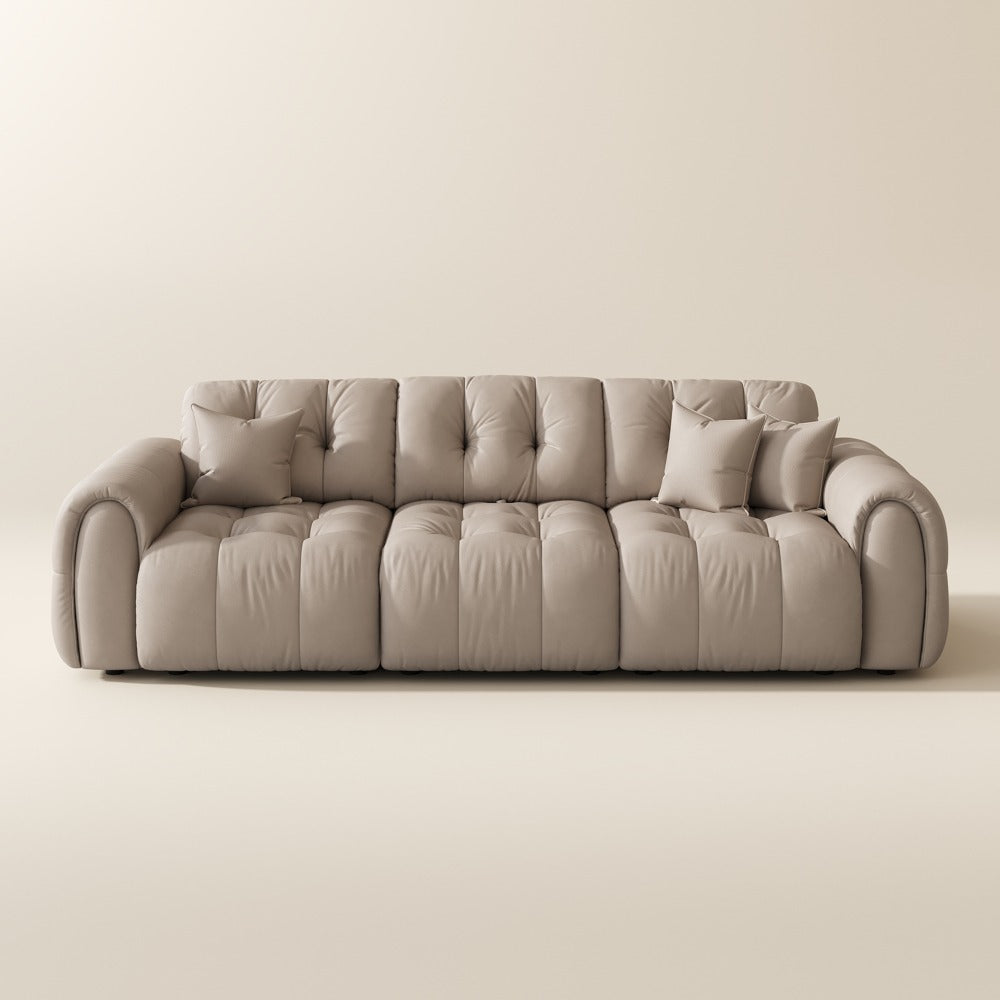 119.5-inch beige top-grain leather tufted modular sofa with pillows on a plain background