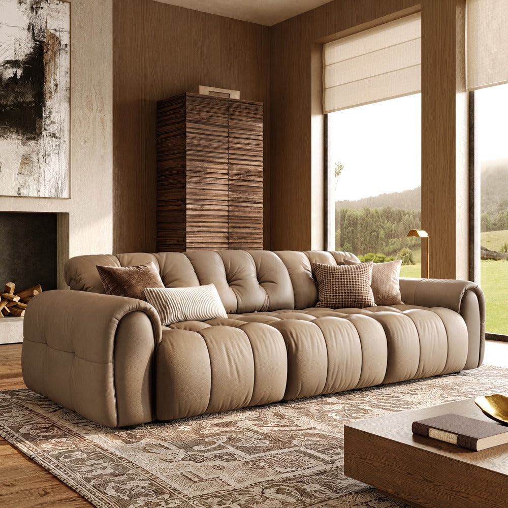Khaki leather tufted modular sofa with three armless seats and two armrests, front view in a living room