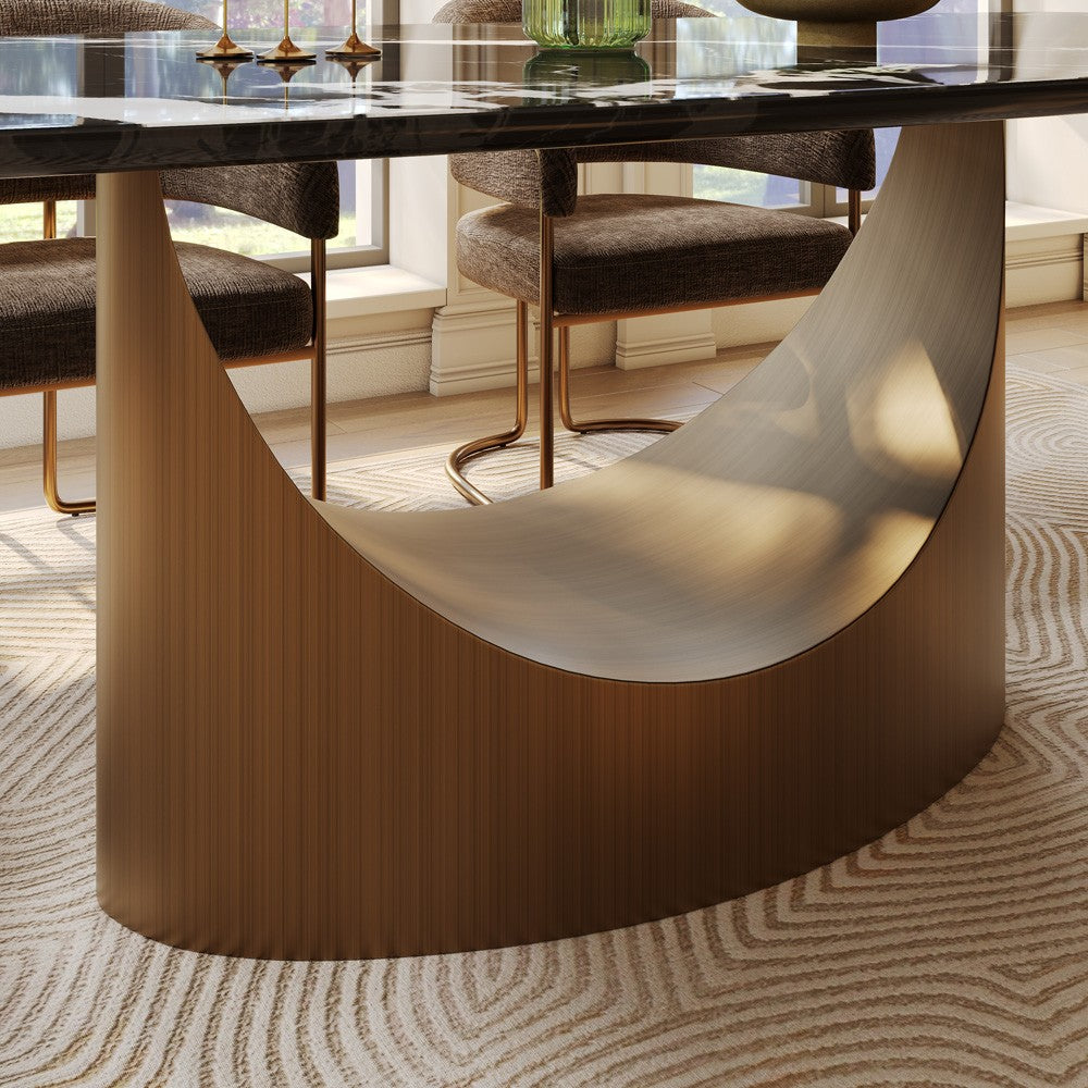 Curved bronze-finish stainless steel pedestal base under black marble top, close-up