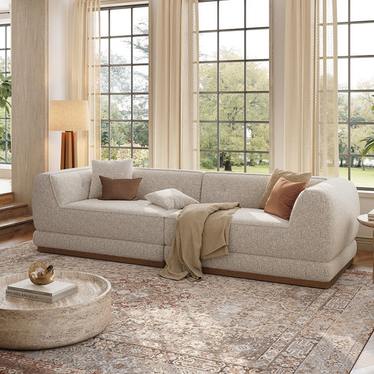 Light gray chenille sofa with wooden base in a bright living room